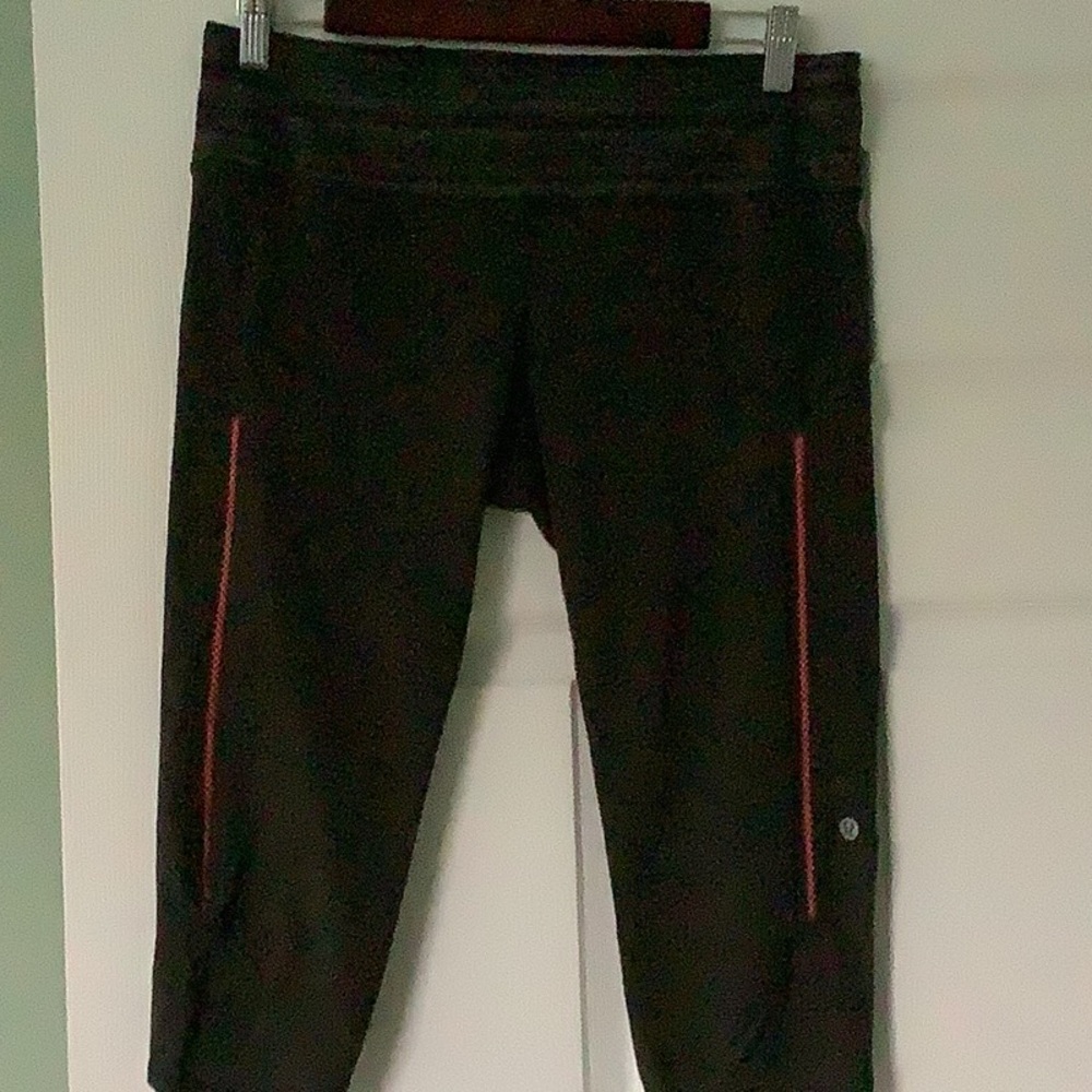 Lululemon crop tight . Color sage green with orange accent on side of legs.